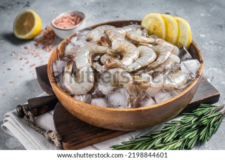 Uncooked Raw peeled tiger white shrimp prawn. Gray background. Top view. Royalty-Free Stock Photo #2198844601