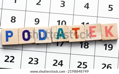 "Podatek" translated as "Tax"  word composed of wooden letters on a piece of paper of the calendar. It's time to settle accounts with the office. Royalty-Free Stock Photo #2198848749