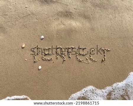 on the beach is carved with letters in the smooth sand the writing Perfect