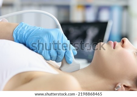 Woman receives ultrasound of thyroid gland from doctor Royalty-Free Stock Photo #2198868465
