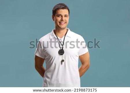 Swimming coach with a wistle and stopwatch around his neck isolated on blue background Royalty-Free Stock Photo #2198873175