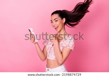Photo of excited attractive lady point finger telephone flying hair isolated on pink color background
