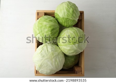 White cabbage in crate on wooden table, top view Royalty-Free Stock Photo #2198893535