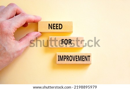 Need for improvement and support symbol. Concept words Need for improvement on wooden blocks. Businessman hand. Beautiful white background. Business, need for improvement quote concept. Copy space.