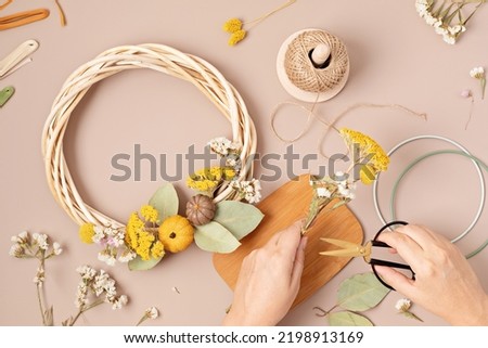 Proccess of creation handmade wreath with dry flowers. DIY autumn decoration idea. Artisan, small business, sustainable decor for fall holidays concept  Royalty-Free Stock Photo #2198913169