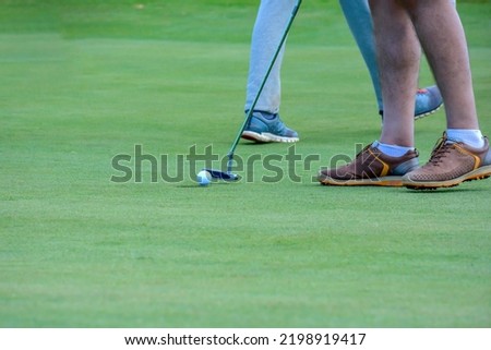The picture shows a Golf player while hitting the ball from tee

