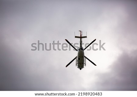 Helicopter close-up on the background of a stormy sky. Rescue helicopter flies in the sky with clouds.