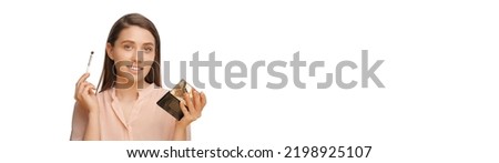 Panorama photo of a gorgeous woman holding eye shadows case and a brush. Studio shot over white background with a lot of copy space.