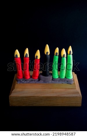 Kinara. Traditional Kwanzaa symbols. Isolated on black background. African American holiday. Hand-sculpted kinara from plasticine