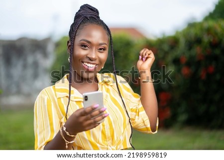 image of excited african lady with smartphone Royalty-Free Stock Photo #2198959819