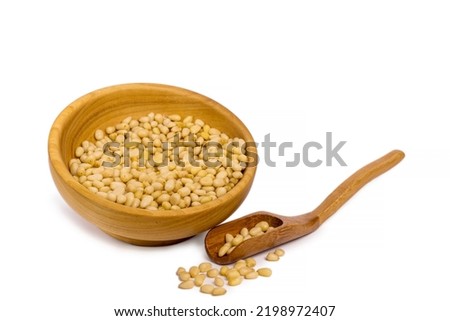 Raw pine nuts in wooden scoop isolated on white background. High quality photo