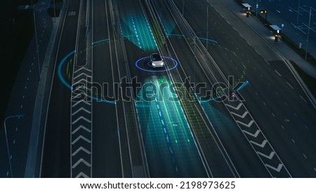Following Aerial Drone View: Autonomous Self Driving Car Moving Through City Highway. Visualization Concept: Sensor Scanning Road Ahead for Vehicles, Danger, Speed Limits. Evening Urban Driveway Royalty-Free Stock Photo #2198973625