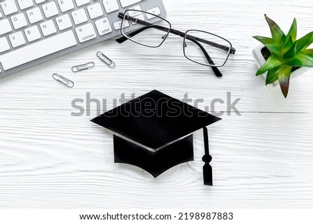 Graduation hat on students table. Masters or Bachelors degree concept