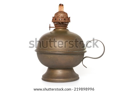 An old bronze oil lamp with wick isolated on a white background