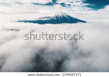 Tolbachik volcano with clouds at sunrise. Kamchatka peninsula, Russia. Aerial drone view. Beautiful summer landscape