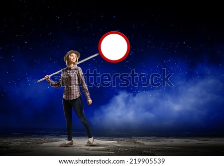 Young girl in casual holding stop sign