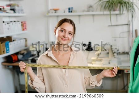 Portrait of confident young Indian female entrepreneur standing in atelier she owns. High quality photo