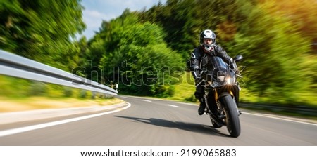 motorbike on the forest road driving. having fun driving the empty road on a motorcycle tour journey. copyspace for your individual text. motion blur shot Royalty-Free Stock Photo #2199065883