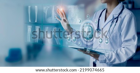 Medicine doctor hand touching on a patients x-ray scans digital healthcare and connection with modern virtual screen interface icons, Medical technology and network concept.