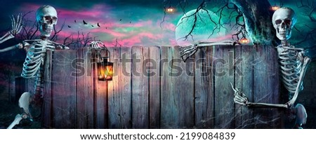 Halloween Party - Skeletons With Wooden Banner In Spooky Nights Royalty-Free Stock Photo #2199084839