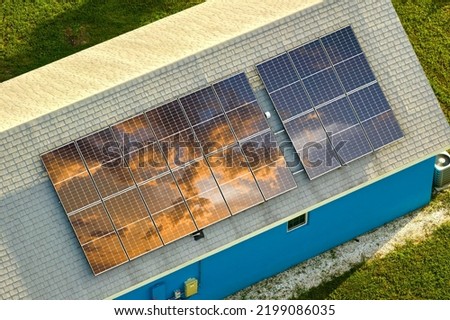 Aerial view of typical american building roof with rows of blue solar photovoltaic panels for producing clean ecological electric energy. Renewable electricity with zero emission concept Royalty-Free Stock Photo #2199086035