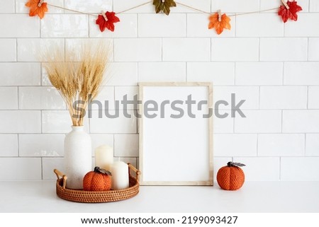 Picture frame mockup with autumn fall decorations on tile wall background. Thanksgiving, Halloween holiday poster design.