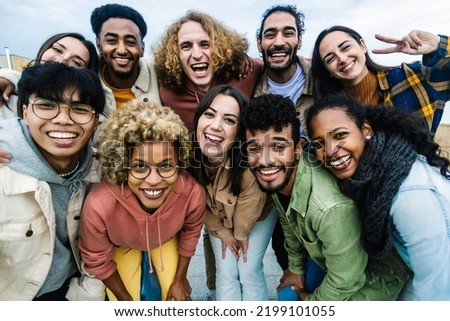 Young multiracial people having fun together outdoor - Big group portrait of happy young student friends taking photo together at city street