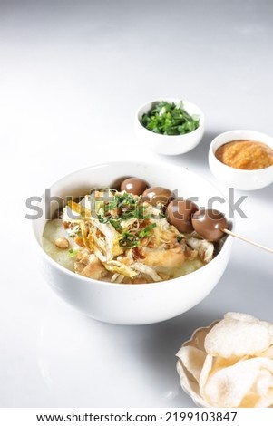 Bubur Ayam or Indonesian Rice Porridge with Shredded Chicken, cheese stick and cakwe. Royalty-Free Stock Photo #2199103847
