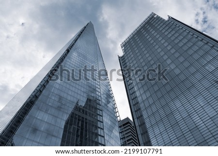 Two contemporary glass and steel high rise towers reach for the sky as part of a contemporary cityscape
