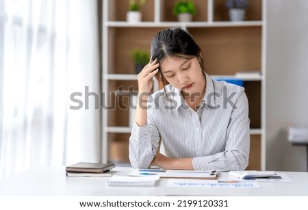 Asian women are stressed while working on laptop, Tired asian businesswoman with headache at office, feeling sick at work, copy space Royalty-Free Stock Photo #2199120331