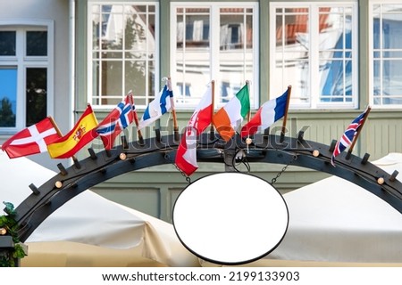 Street signage light box signboard with flags of Europe countries. Round sign board, mock up for company name or logo, exterior. Circular cafe, restaurant outdoor welcoming board