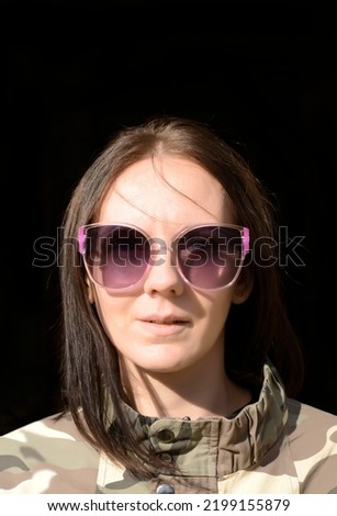 portrait of brutal woman in stylish khaki green jacket. Autumn fashion. front view. fashion lifestyle fashion portrait of young girl isolated on black background,wearing outfit, bomber, sunglasses
