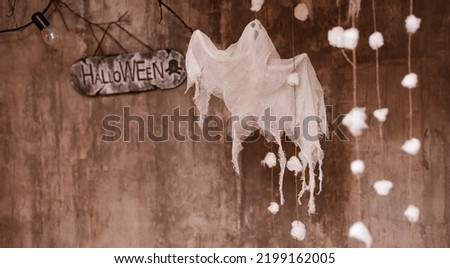 Halloween background on a concrete background with a cast and a sign with an inscription, free space for text Diy Halloween ghost of starch and gauze invitations and advertising.