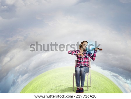Young pretty girl in casual playing violin