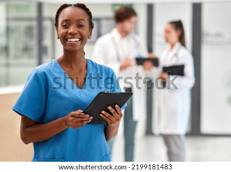 Portrait of happy woman doctor working on a digital tablet and smile while working at a hospital. Black female nurse doing medical and healthcare research on the internet or online at work at clinic Royalty-Free Stock Photo #2199181483