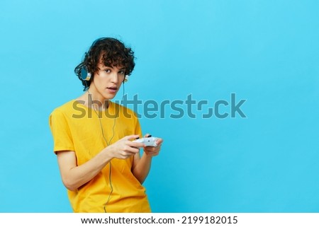 curly guy yellow T-shirt with joystick video games isolated backgrounds