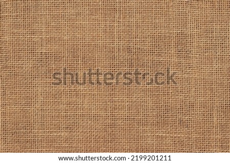 Brown burlap cloth background or sack cloth for packing. Natural linen threads texture. Sackcloth, empty space. Wrapping detail, old grainy cotton backdrop close-up. Royalty-Free Stock Photo #2199201211