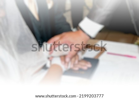 Defocused photo, blurry background, blur blessed hands on top of holy bible in a wedding ceremony, bride and groom hands