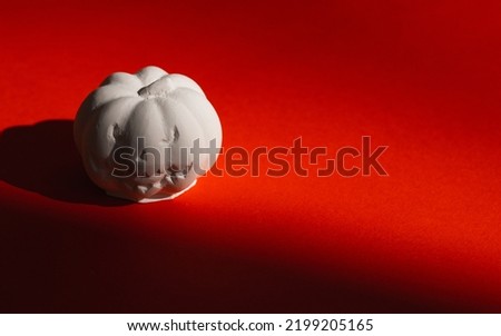 plaster figure of a pumpkin on a red background. Halloween concept