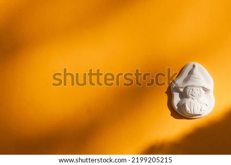 plaster figure of a pumpkin and skull on yellow background. Halloween concept