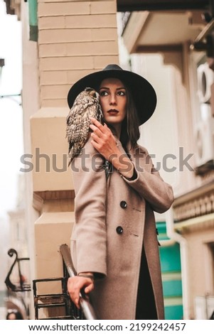 very beautiful girl in a hat with an owl. High quality photo