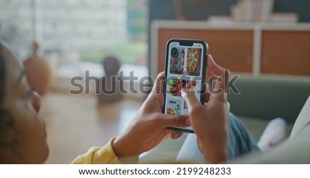 Closeup female hands holding cellphone browsing food online menu on phone. Person searching for food order on application device