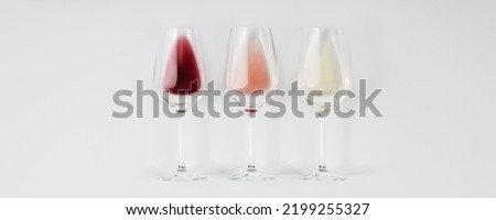 Banner. Flat-lay of red, rose and white wine in glasses on white background. Wine bar, winery, wine degustation concept. Minimalistic trendy photography