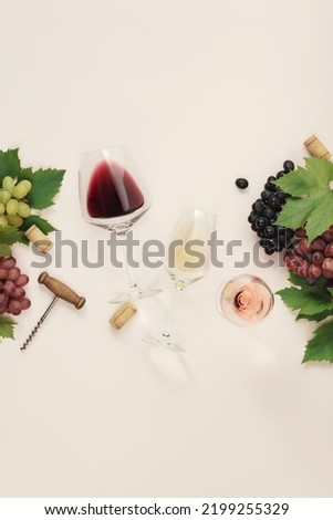 Flat-lay of red, rose and white wine in glasses, Branch of grape vine and grape on pink background. Wine bar, winery, wine degustation concept. Minimalistic trendy photography