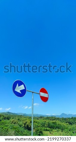 Defocused and Blur Photo of a pole and a traffic sign with a forest background and blue sky - Indonesia, Not Focus