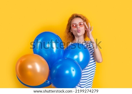 party girl with balloon in sunglasses. girl blow kiss hold party balloons in studio.