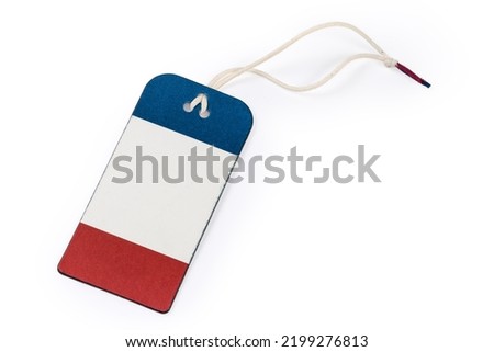 Blank clothing swing tag in the form of red white blue carton sheet on a white rope on a white background
