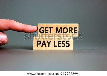 Get more pay less symbol. Concept words Get more pay less on wooden blocks on a beautiful grey table grey background. Businessman hand. Business Get more pay less concept. Copy space. Royalty-Free Stock Photo #2199292991