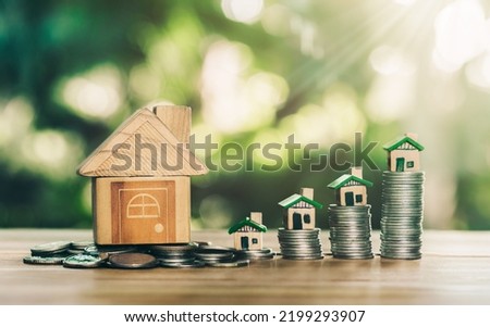 House placed on coins and coins place on the wood table is ladder. planning savings money of coins to buy a home concept concept for property ladder, mortgage and real estate investment.