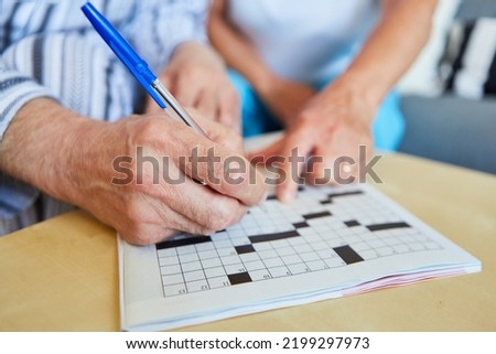 Two seniors do crossword puzzles at home or in a nursing home as memory training Royalty-Free Stock Photo #2199297973